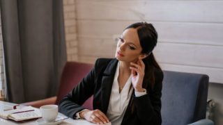 考えている様子のスーツを着た女性
