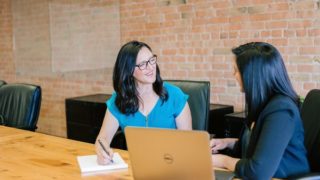 オフィスでPCを前にお話をする2人の女性