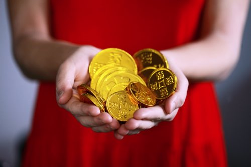 金の硬貨を持つ女性